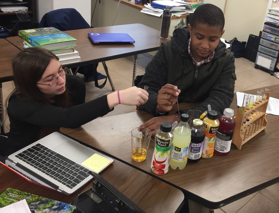 Teacher guiding a student with personalized support during a classroom activity, fostering independence at OPTIONS Transitions to Independence.