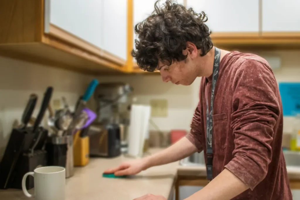 OPTIONS student practicing household cleaning as part of daily living instruction