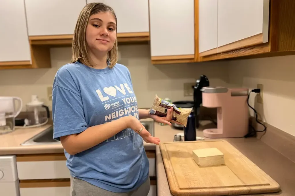 OPTIONS student practicing meal preparation and cooking in an apartment kitchen